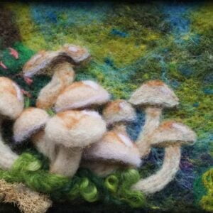 A cluster of small brown mushrooms crafted from needle felted wool some 2d and some 3d sit in front of a dark brown and vibrant cerulean blue and green background